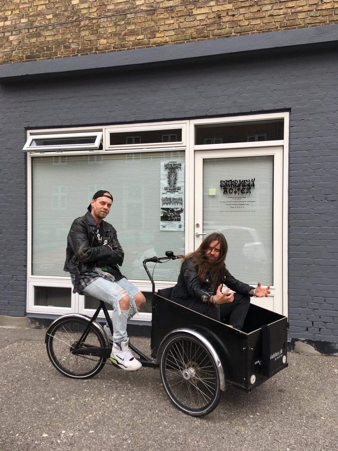 David from Extremely Rotten Productions sitting on a cargo bike with Jesus from Me Saco Un Ojo Records as the cargo